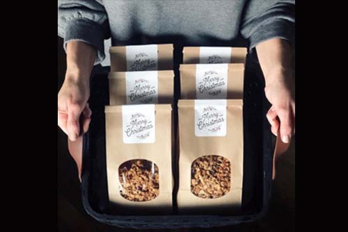 A person holding a tray of granola packages